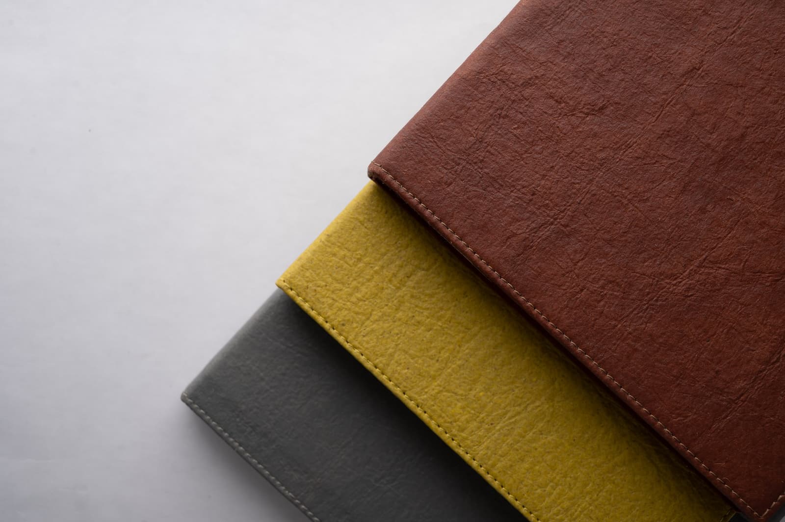 Stacked brown, yellow, and gray Rewrite notebook covers